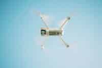 Drone com câmera e drone sem câmera lado a lado sobre superfície clara